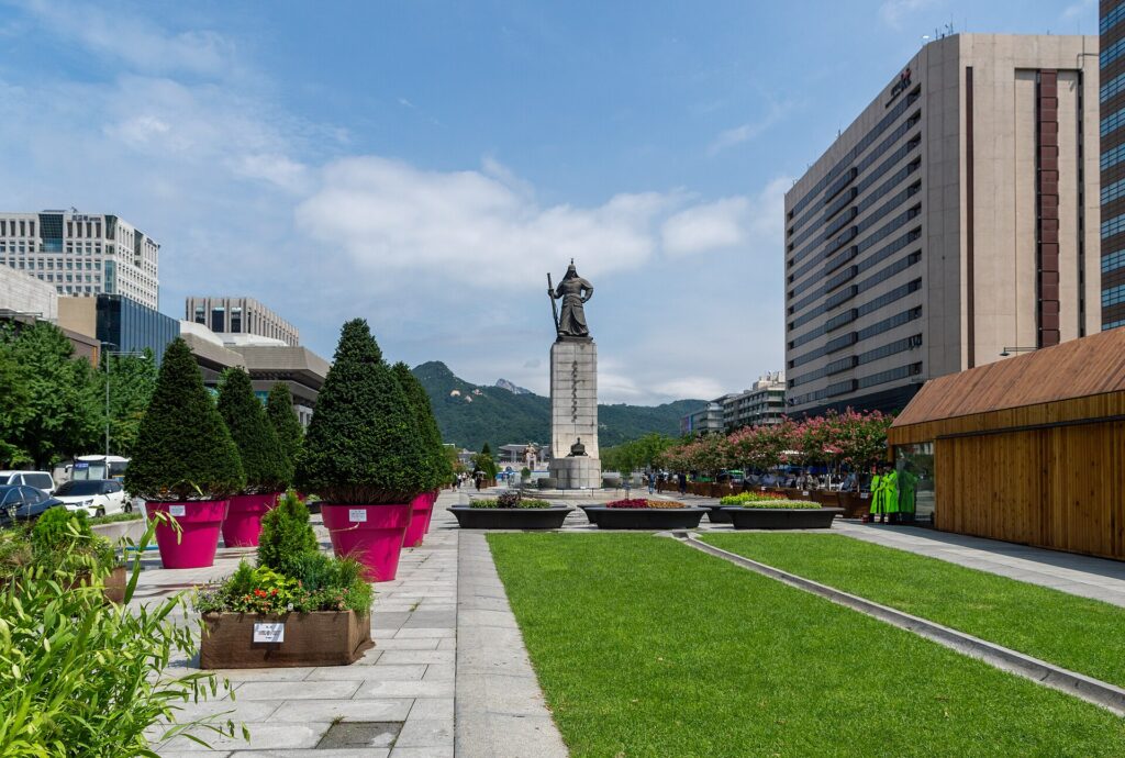 이순신 장군 동상과 북산이 보이는 광화문광장 전경이에요. 넓은 길을 따라 산책하며 둘러보세요.