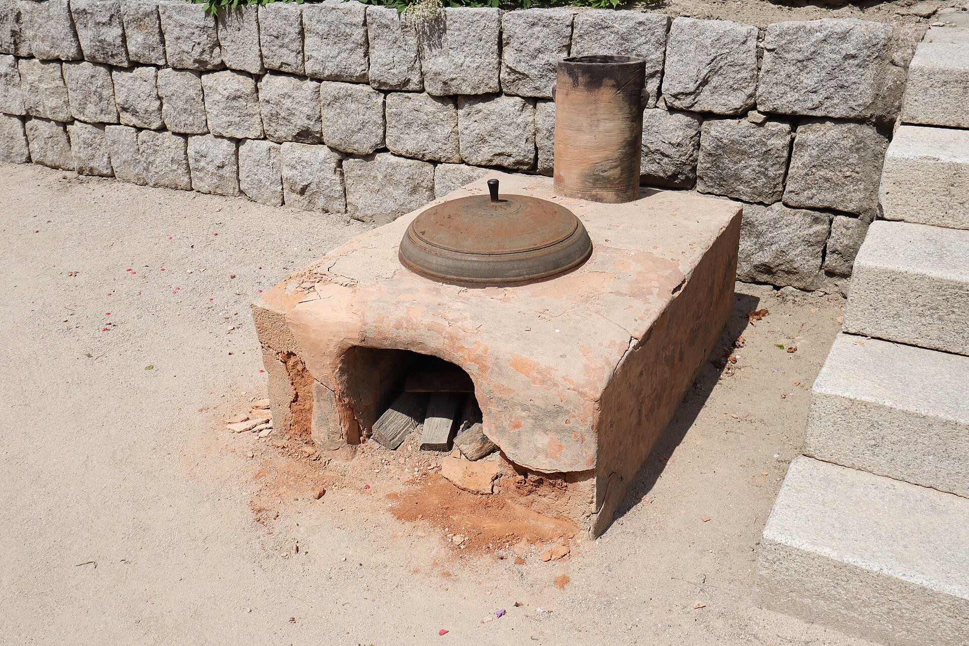 A hearth and pot beside a wall.