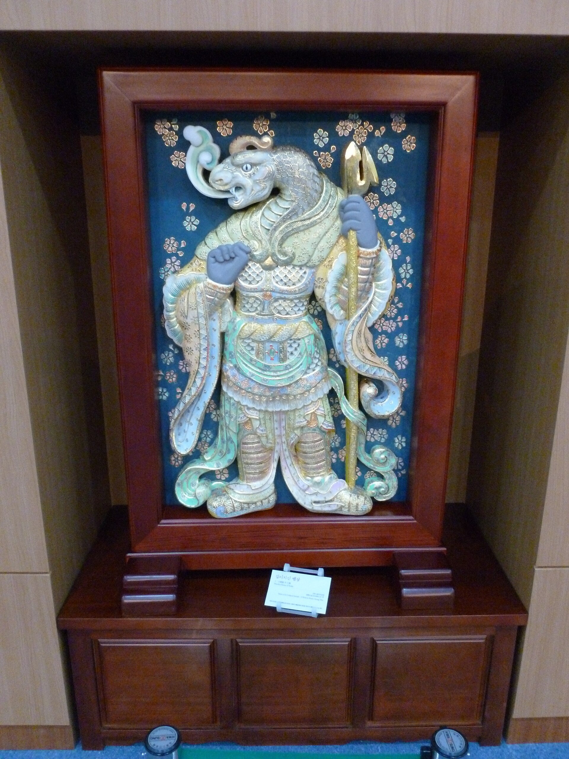 A framed decorative figure photographed in Busan Museum